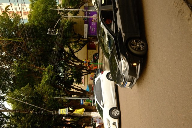 Traffic passing a stilt performer from Max Nicholson's archive